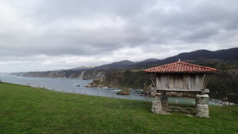 horreo, traditional granary building from the north of spain in a cliff next to the sea in cadavedo, asturias, spain.