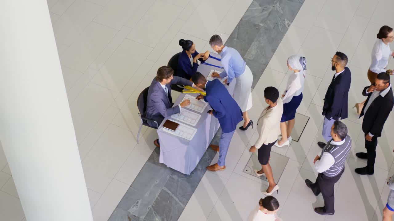 Business people checking in at conference registration table 4k