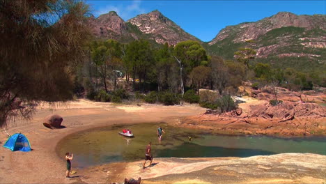 hikers set up a camp with ten along the shore of coles bay tasmania australia