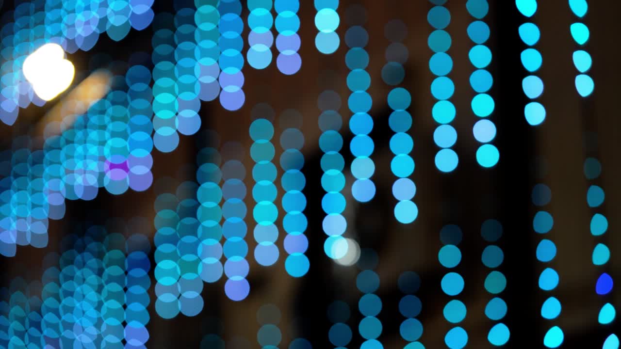Abstract colorful bokeh lights video with defocused serial lighting. Soft blurred blue and cyan circles create a modern glowing background, ideal for creative motion graphics and elegant overlays