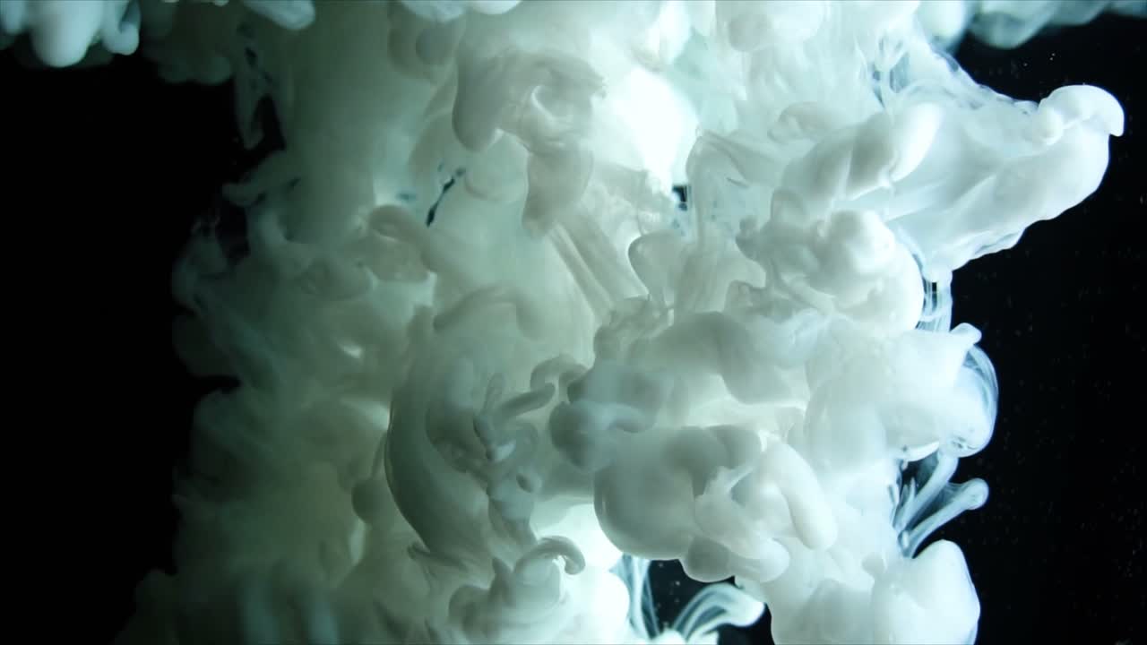 Abstract White Ink Swirling and Spreading in Dark Water