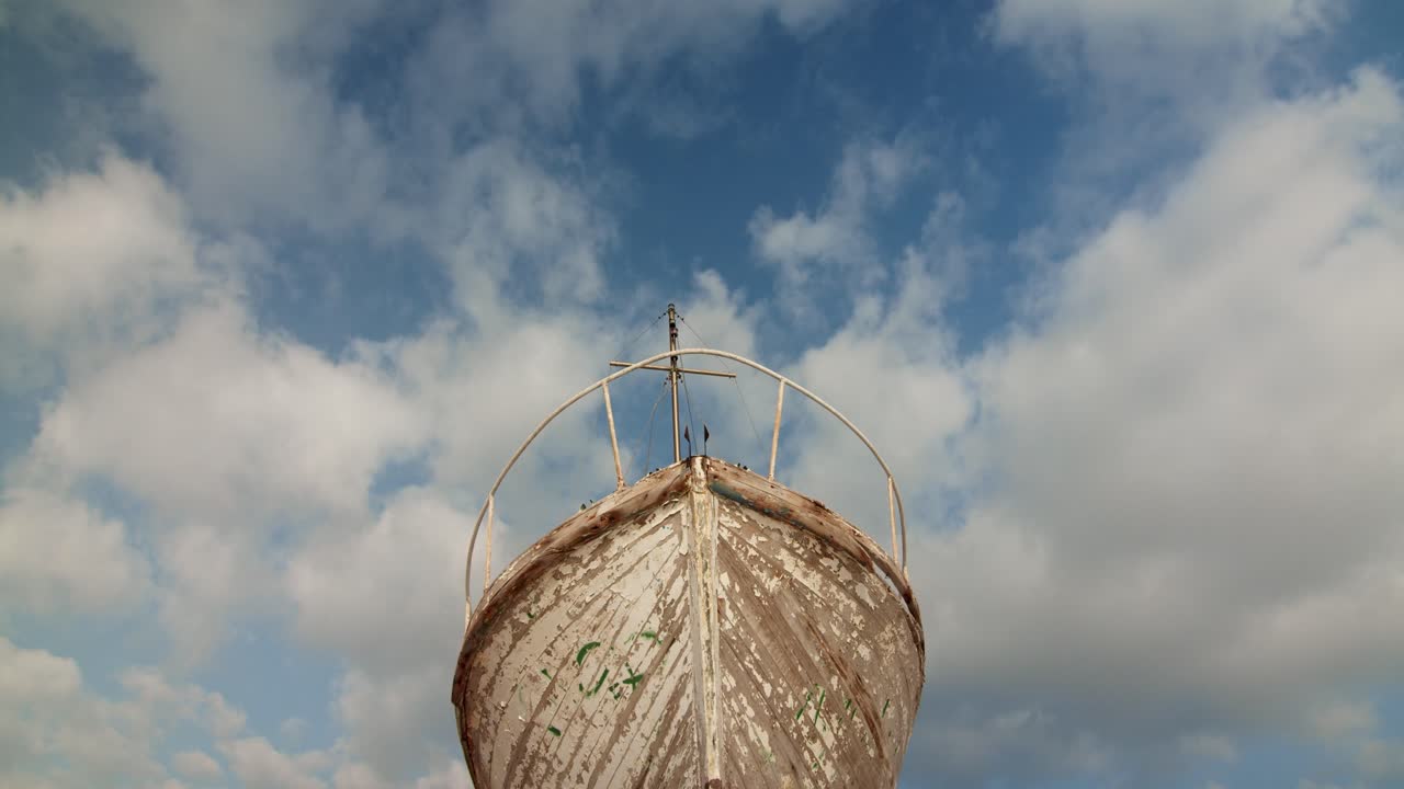 tiro de ángulo bajo del cielo de la ruina del barco viejo con nubes filmación de establecimiento cinematográfico, tiro de día simétrico de barco antiguo de madera abandonado