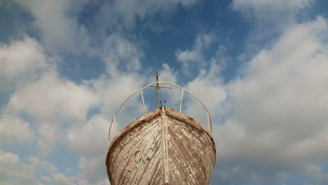 low angle shot of old boat ruin sky with clouds cinematic establishment shot , abandoned wooden ancient ship symmetrical day shot