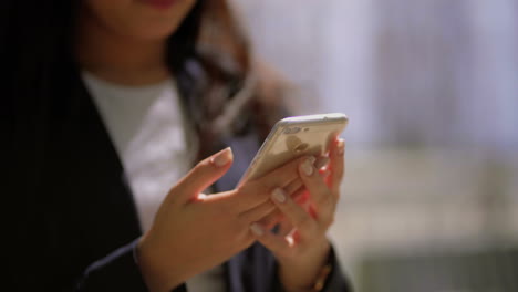 foto recortada de una mujer usando un teléfono celular al aire libre