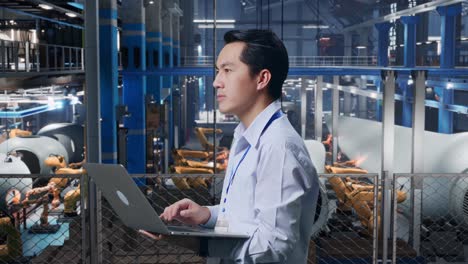 ingeniero trabajando en una computadora portátil en una fábrica