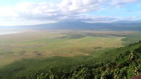 young woman photographing with a phone the marvelous green volcanic crater of the ngorongoro volcano