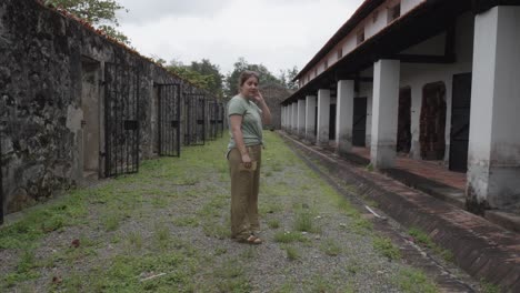 mujer adulta de pie fuera de las viejas celdas abandonadas de la prisión de con dao en vietnam