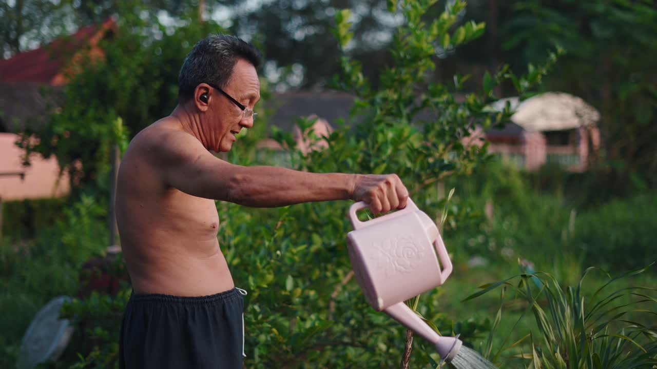 Elderly Man Watering Plants in Garden