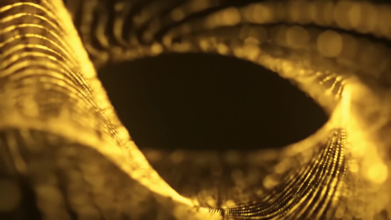 A captivating display of light dances through intricate textures, creating an enchanting golden wave. Observe the fluid movement and shimmering patterns that evoke a sense of tranquility.