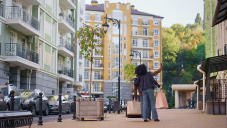 Pareja-Feliz-Tomando-Selfie-Caminando-Por-La-Zona-Residencial-Después-De-Ir-De-Compras-Vista-Trasera.