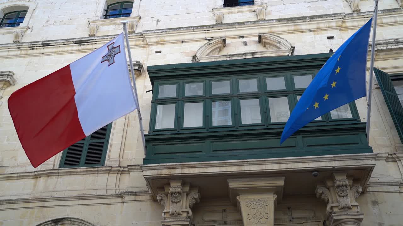 Malta and EU Flag waiving in the wind outside a traditional Maltese balcony at the Ministry of Foreign Affairs in Valletta