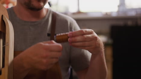 El-Hombre-Enrolla-Hilo-Encerado-Para-Coser-Cuero-En-Taller-Artesanal.