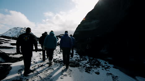 hikers in a snowy volcanic landscape