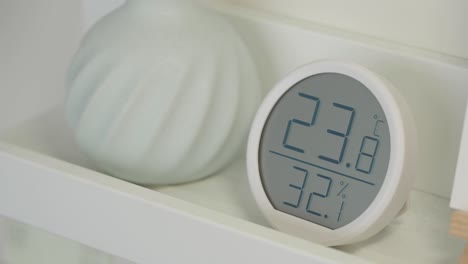 digital hygrometer on a white shelf