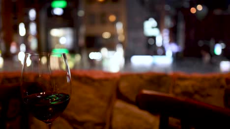 wine glass slowly fills against a blurred city backdrop