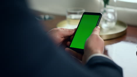 Closeup-hands-holding-smartphone-with-chroma-key-screen.-Man-using-mockup-phone