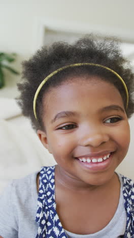 vertical video portrait of happy african american girl smiling in living room