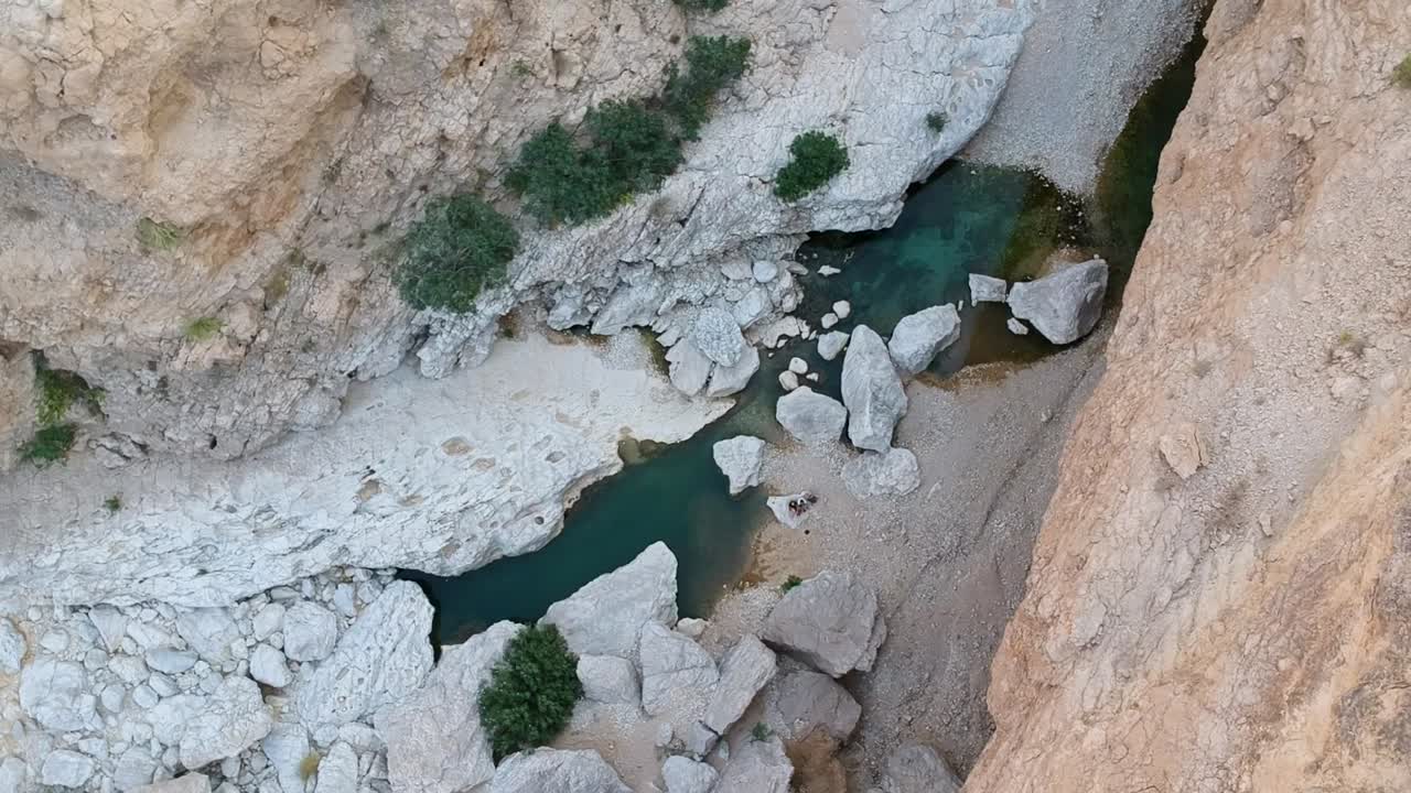 drone aéreo del increíble oasis de wadi tiwi con agua turquesa y cañón en el sultanato de omán