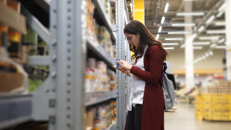 woman shopping for canned goods in a grocery store