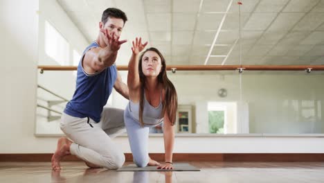 instructor caucásico y estudiante practicando yoga en el gimnasio, cámara lenta