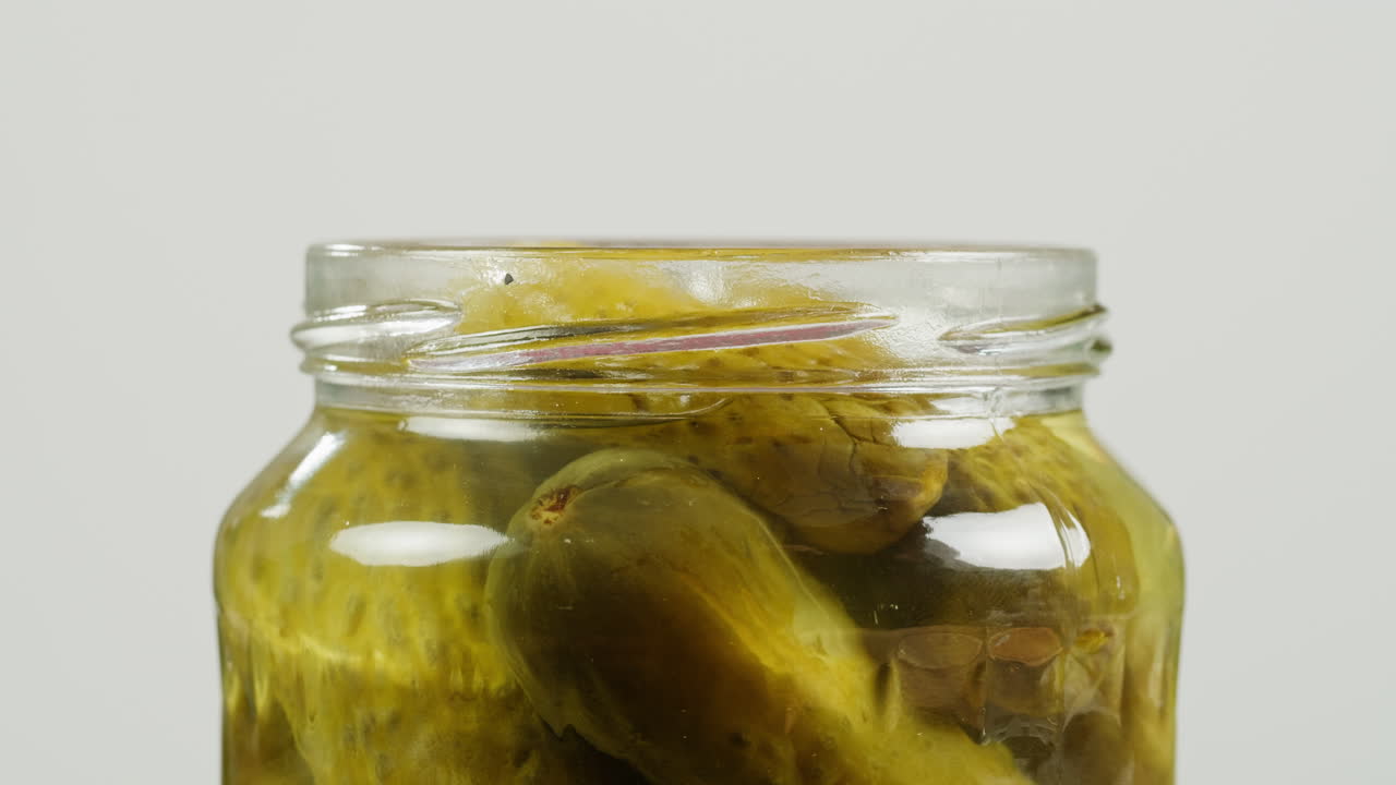 Hand placing lid on a jar of pickles