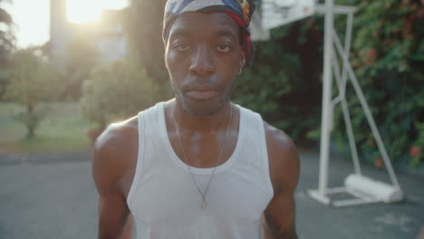 portrait of confident black man with basketball training on outdoor court