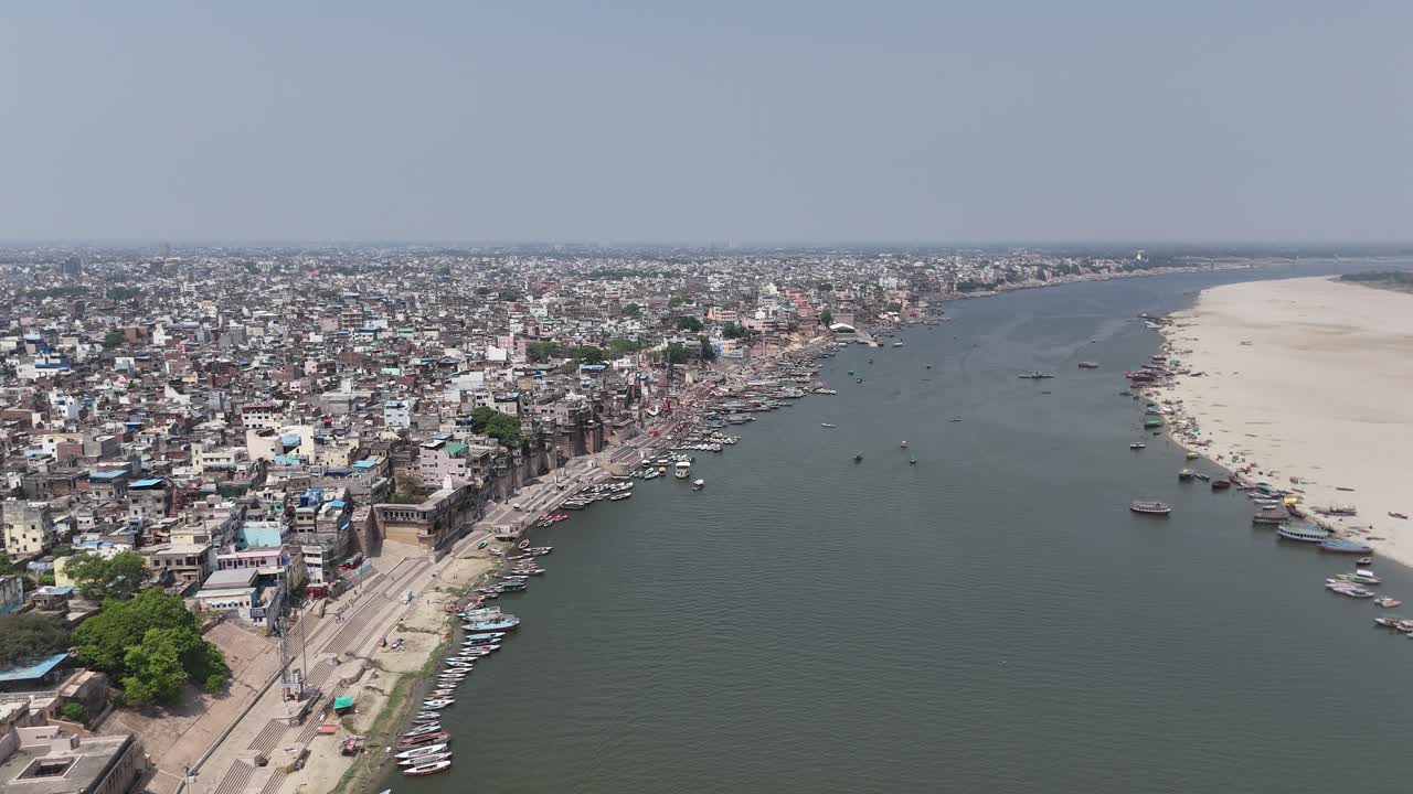 Ganges River flowing alongside densely packed urban landscape in Varanasi.