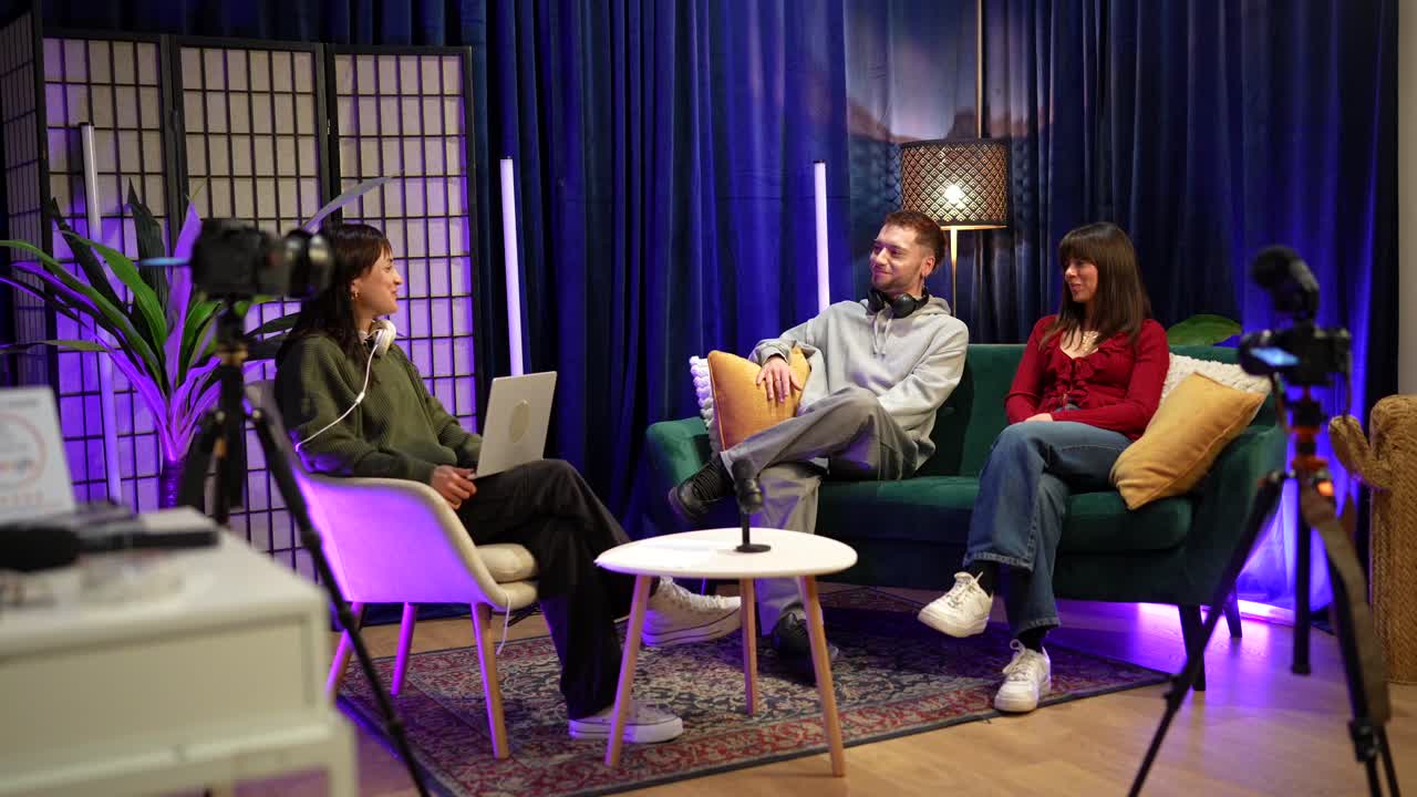 Tre unge voksne spiller inn en podkast i et moderne studio