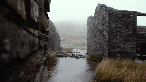 old buildings hammered by wind and rain at the the abandoned miner’s village of the cwmorthin slate quarry in the moelwyn mountains near tanygrisiau, north wales