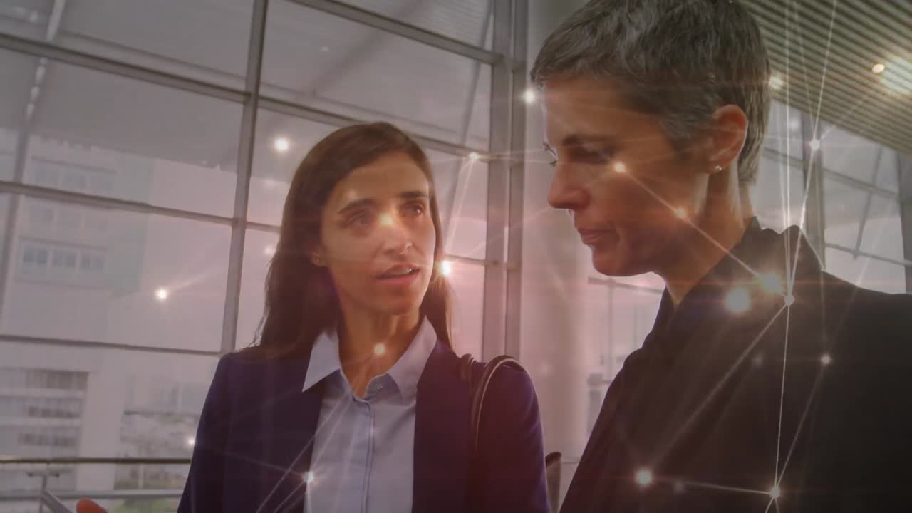 animación de la red de conexiones sobre dos mujeres de negocios diversas discutiendo en la oficina