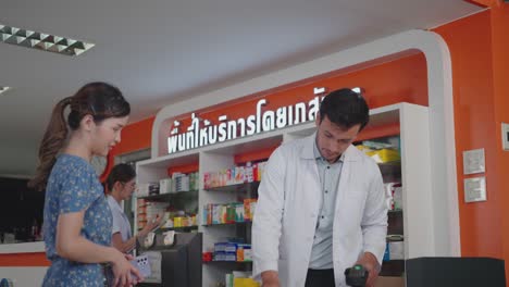 caucasian male pharmacist selling medicine to customers.