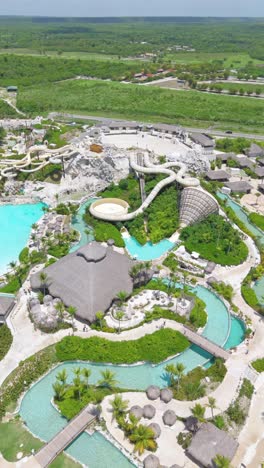 aerial view of el dorado park wave pool and slides, and surrounding landscape, cap cana, dominican republic. vertical format