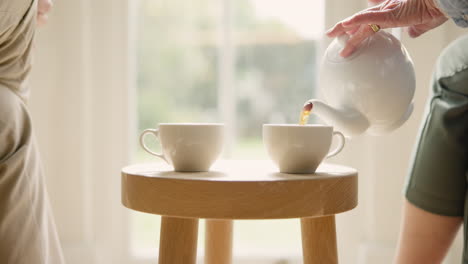 Senior-couple,-hands-and-pouring-tea-at-house