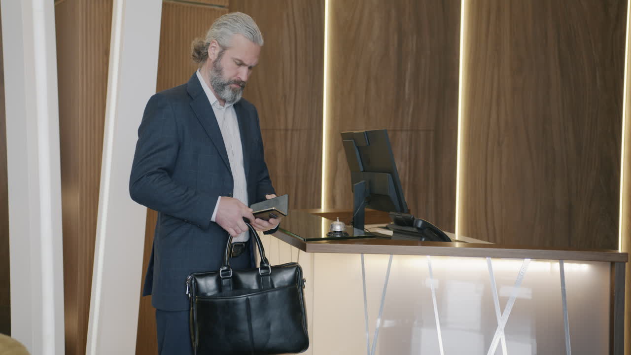 Businessman Checking In at Hotel Reception