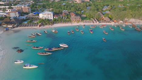 vista aérea de una playa de arena con barcos y gente de fondo, aldea de kendwa, zanzíbar, tanzania