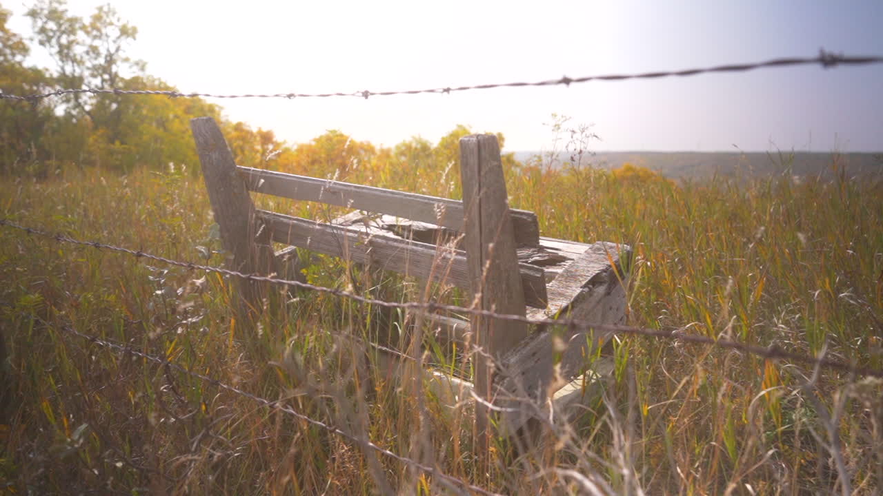 철조망 울타리 뒤에 있는 오래된 나무 벤치