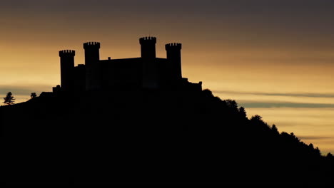 silhouette of a castle on a hill at sunset