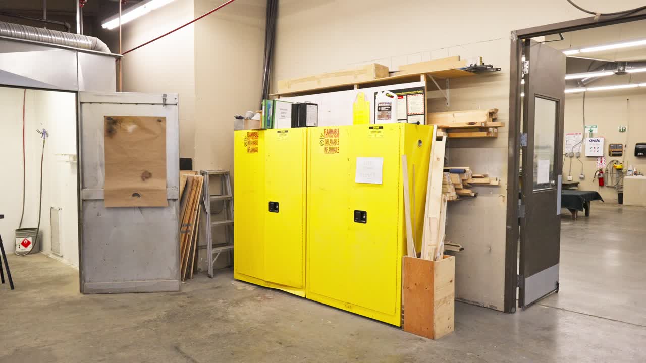Gimbal shows yellow metal storage shelf unit in warehouse with paint booth