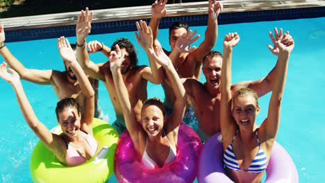 group of happy friends having fun together in swimming pool