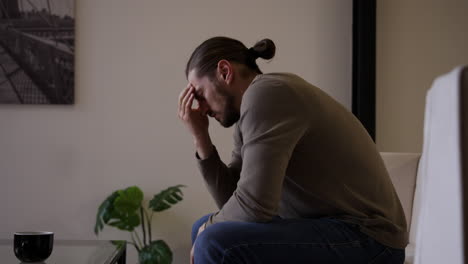 Caucasian-man-with-headache-sitting-on-a-chair