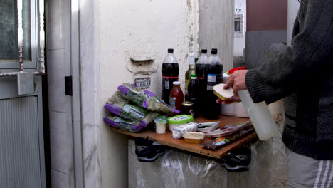 poor man disinfects his groceries before entering his home during the covid-19 quarantine, in lisbon, portugal