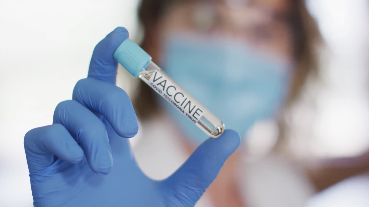 maestra caucásica con máscara facial en la escuela, mirando una sonda. educación de vuelta a la escuela h