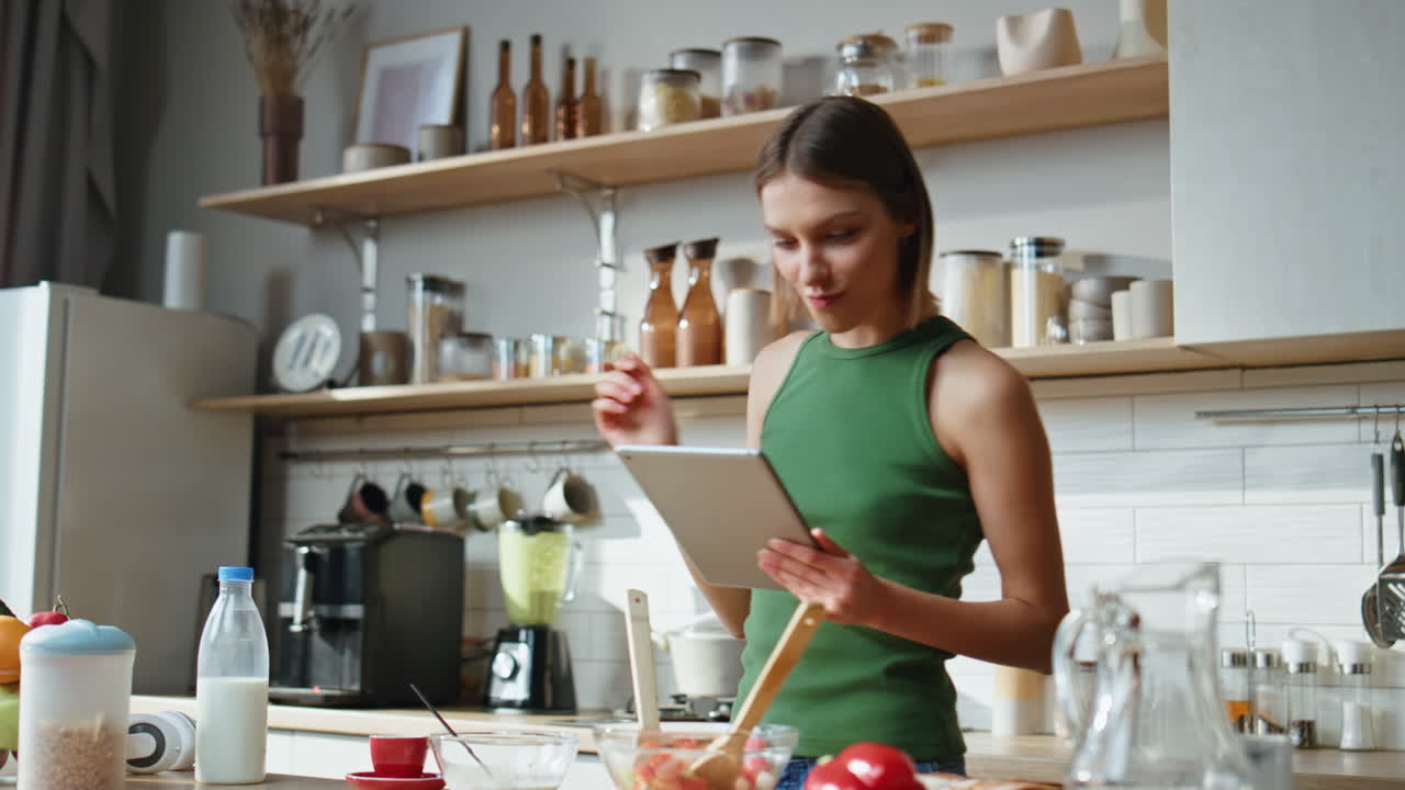 mujer usando tableta en la cocina