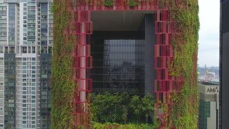 rascacielos moderno con jardín vertical y fachada roja