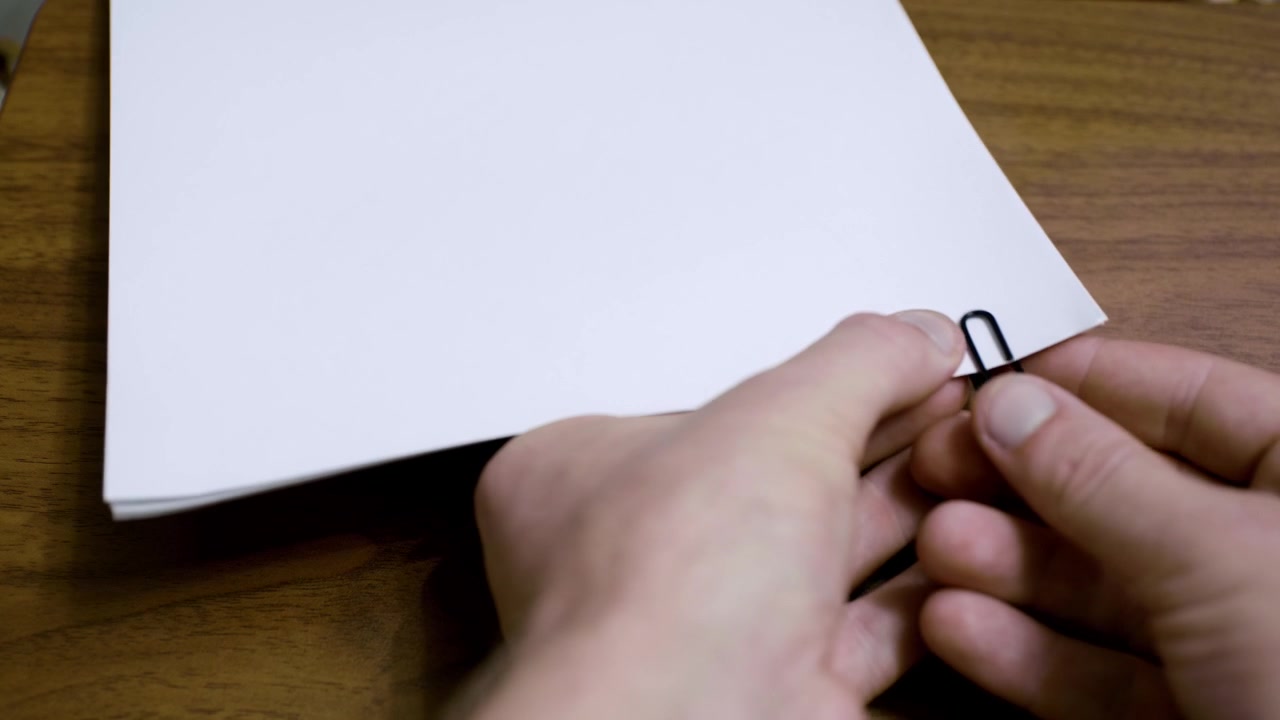 Graffetta che collega una pila di fogli. Fogli formato A4 per stampante uniti con un fermacampioni.