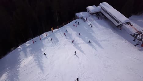 Aerial-view-of-ski-resort-with-people-snowboarding-down-the-hill