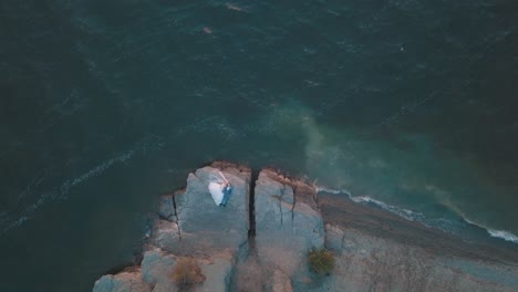 Wedding-newlyweds-couple-are-lying-on-a-mountainside-by-the-sea.-Aerial-shot