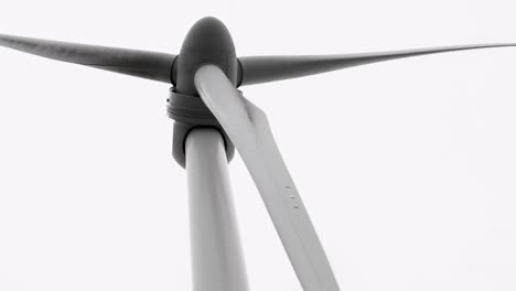 detailed view of wind turbine blades rotating against a clear sky, showcasing mechanical precision and engineering.