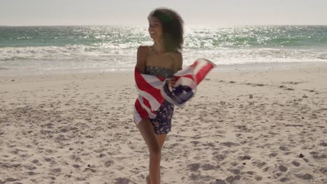 Frau-Läuft-Mit-Amerikanischer-Flagge-Am-Strand-4k