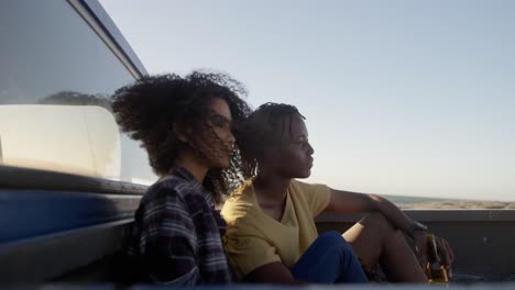 Couple-relaxing-on-a-pickup-truck-at-beach-4k